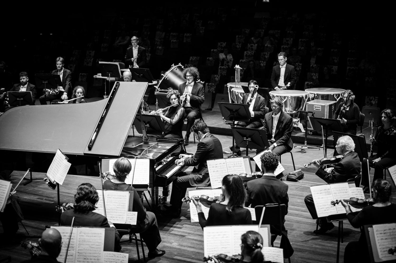 Het orkest in de ronde opstelling met dirigent Lahav Shani (op de vleugel) in het midden.